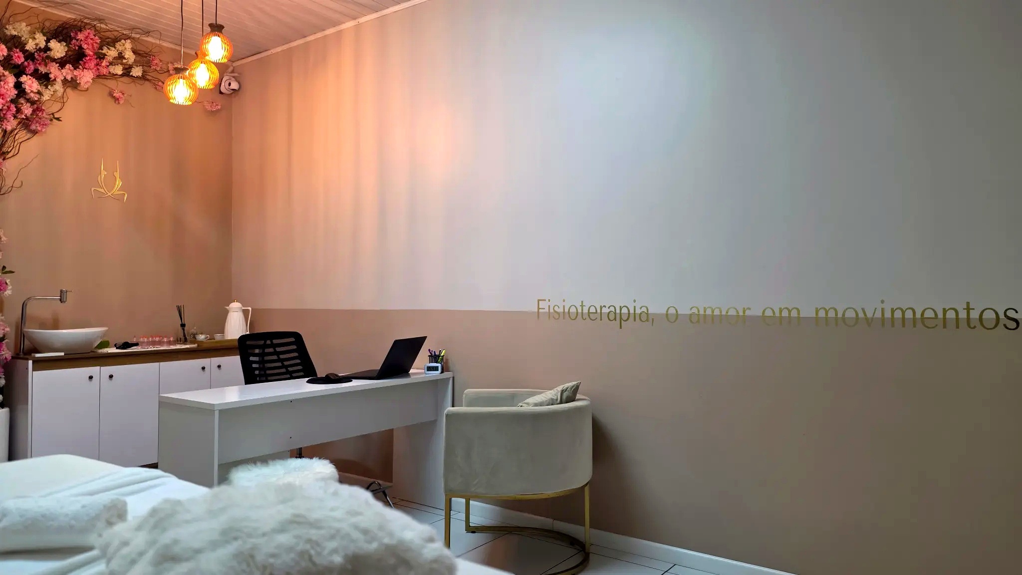 Ambiente tranquilo de massagem clínica com maca e toalhas brancas, iluminação suave.